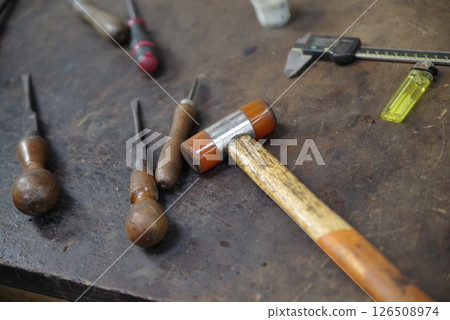 Table with a hammer and a few other tools on it 126508974