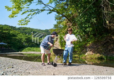 Two men having a barbecue Two men having a barbecue 126509738