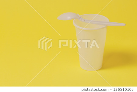 Horizontal photo of a plastic glass with a spoon. Horizontal photo of a plastic glass with a spoon. 126510103