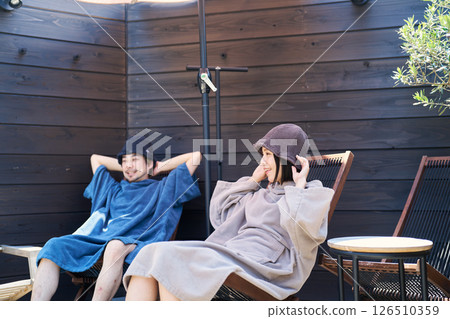Men and women sitting and cooling off after coming out of the sauna 126510359
