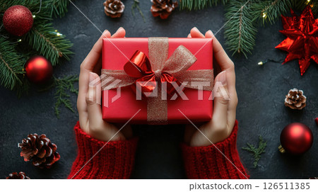 Hands Holding Christmas Gift Wrapped in Red with Ribbon Hands Holding Christmas Gift Wrapped in Red with Ribbon 126511385