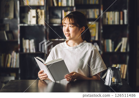 Young Asian woman (college student) reading in her study 126511486
