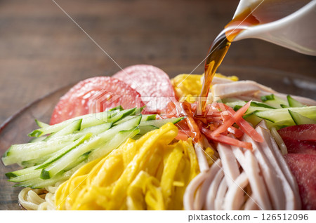 Pour soy sauce over chilled Chinese noodles 126512096