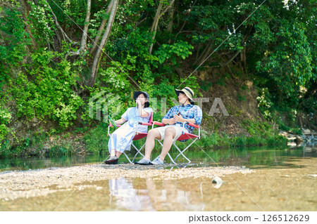 Men and women cooling off by the river 126512629