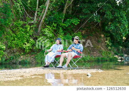Men and women cooling off by the river Men and women cooling off by the river 126512630