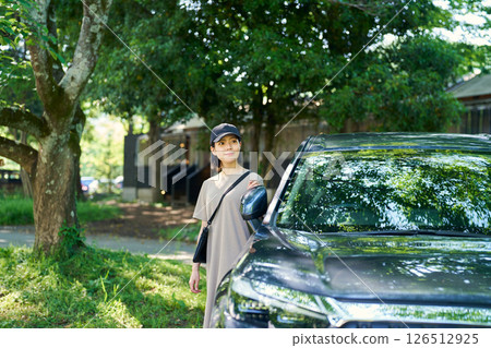 A woman getting off the car 126512925