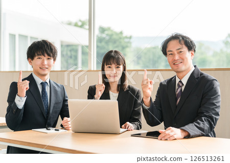 Male and female businessmen having a meeting in a conference room (pointing, pointing, recommending) 126513261
