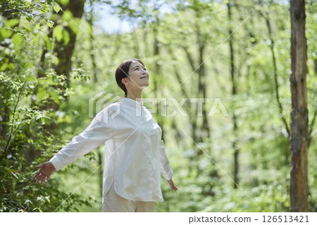 Japanese woman enjoying forest bathing in nature 126513421