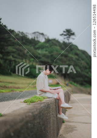 A man in his 20s working remotely at a resort 126514498