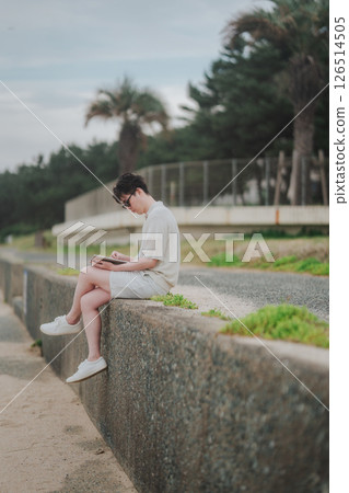 一名 20 多歲的男子在度假村遠距工作 一名 20 多歲的男子在度假村遠距工作 126514505