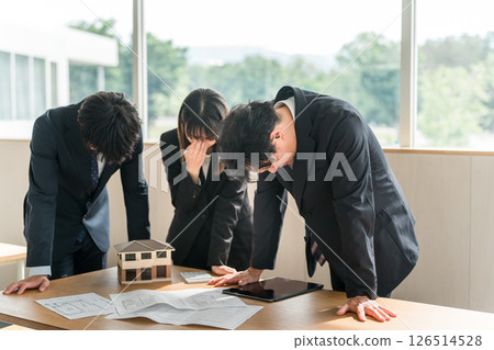 Depressed and disappointed businessmen and women at a conference table Depressed and disappointed businessmen and women at a conference table 126514528