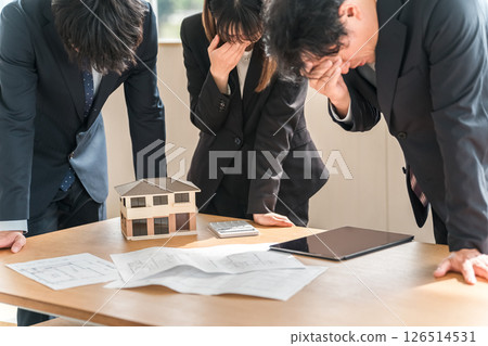 Depressed and disappointed businessmen and women at a conference table Depressed and disappointed businessmen and women at a conference table 126514531
