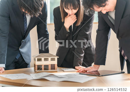 Depressed and disappointed businessmen and women at a conference table Depressed and disappointed businessmen and women at a conference table 126514532