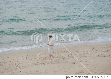 A man in his 30s wearing sunglasses working remotely at a resort 126515064