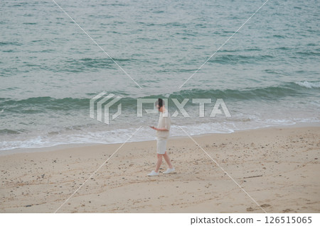 A man in his 30s wearing sunglasses working remotely at a resort 126515065