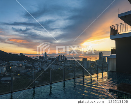 Stunning sunset over the city skyline from a rooftop pool in urban high-rise 126515106