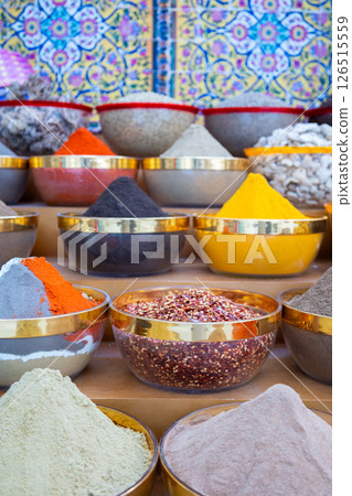 Traditional spices market. Pots and wooden tubs stand in row with colorful tea, spices, fruits, roots, flowers. Street bazaar. Dubai, UAE. Vertical photo 126515559