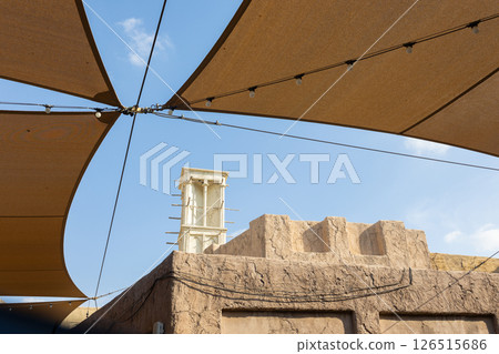 Old town in Al Seef Cultural Historical District on shores of Dubai Creek. Tourist place with old streets, houses and shops, Dubai, UAE. Vertical photo Old town in Al Seef Cultural Historical District on shores of Dubai Creek. Tourist place with old streets, houses and shops, Dubai, UAE. Vertical photo 126515686