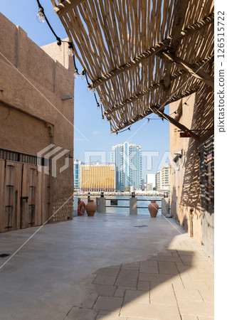 Old town in Al Seef Cultural Historical District on shores of Dubai Creek. Tourist place with old streets, houses and shops, Dubai, UAE. Vertical photo Old town in Al Seef Cultural Historical District on shores of Dubai Creek. Tourist place with old streets, houses and shops, Dubai, UAE. Vertical photo 126515722