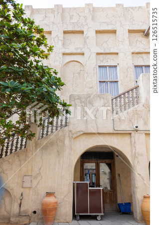 Old town in Al Seef Cultural Historical District on shores of Dubai Creek. Tourist place with old streets, houses and shops, Dubai, UAE. Vertical photo 126515735