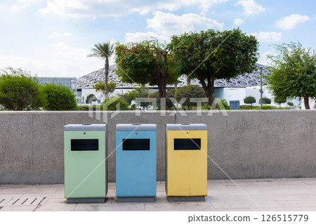 Blue, yellow and green recycling bins for separate garbage on street in Abu Dhabi, Emirates. High quality photo 126515779