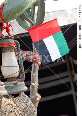 Flag of United Arab Emirates flying high on city of Dubai in old town. National Day UAE. High quality photo Flag of United Arab Emirates flying high on city of Dubai in old town. National Day UAE. High quality photo 126515790
