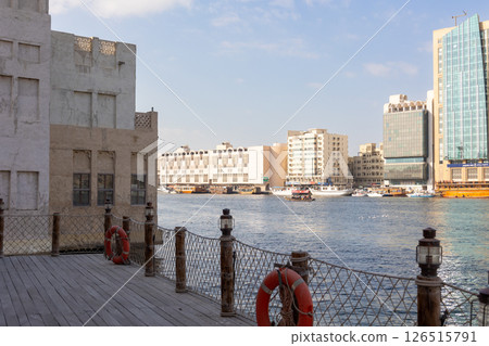 Old town in Al Seef Cultural Historical District. Beautiful view of water, old houses and new ones of Dubai Creek, Dubai, UAE. Taken off hand. High quality photo 126515791