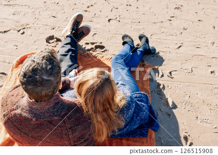 Loving couple walks on beach along sea on sunny autumn day. Weekend and lifestyle concept. Back view. High quality photo 126515908