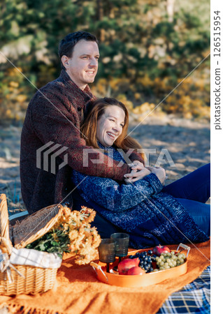 Portrait happy beautiful couple in love enjoying autumn picnic in autumn park. Vertical photo. High quality photo Portrait happy beautiful couple in love enjoying autumn picnic in autumn park. Vertical photo. High quality photo 126515954