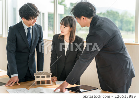 男女商人在房屋模型和藍圖前開會 男女商人在房屋模型和藍圖前開會 126515989