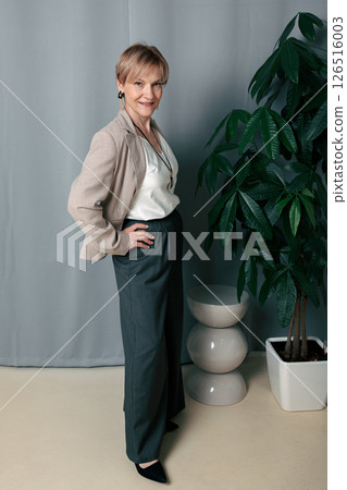 Happy woman. Confident, successful mature woman on light gray background. Looking at camera. High quality photo Happy woman. Confident, successful mature woman on light gray background. Looking at camera. High quality photo 126516003