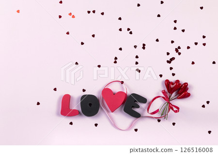 Valentine's day romantic party concept. Gift word LOVE and bouquet of sweet hearts decorations on pink background. Top view, flat lay, copy space 126516008