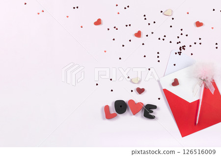 Invitation card to romantic party, wedding or anniversary. Red paper envelope, confetti and sweets in form hearts on light background. Top view, flat lay, copy space Invitation card to romantic party, wedding or anniversary. Red paper envelope, confetti and sweets in form hearts on light background. Top view, flat lay, copy space 126516009