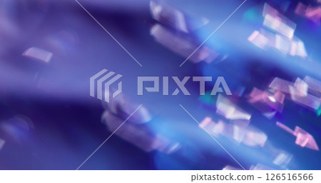 Defocused shine particles. Crystal glow. Gleam white sparks lens flare twirling on blue purple color bokeh light background. Defocused shine particles. Crystal glow. Gleam white sparks lens flare twirling on blue purple color bokeh light background. 126516566