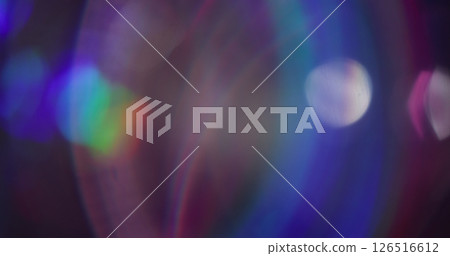 Blurred color sparks. Lens flare. Light blue purple green neon glaring with bokeh effect on abstract dark black background. 126516612
