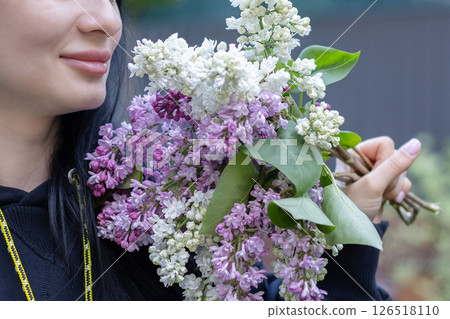 Smiling woman with bouquet of lilac flowers. Closeup. Smiling woman with bouquet of lilac flowers. Closeup. 126518110