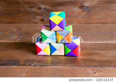 A pile of colorful 3D origami paper 126518147
