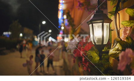 Vintage street lamp illuminating Crimean night with blurred crowd in background 126519384