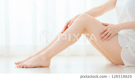 Image of a beautiful white-skinned woman bending her healthy legs and placing her hands on them 126519820