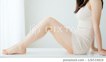 Side angle image of a beautiful fair-skinned woman sitting with her healthy legs bent Side angle image of a beautiful fair-skinned woman sitting with her healthy legs bent 126519828