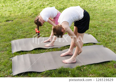 Children practicing yoga outdoors on mats. A healthy and active lifestyle. 126519829