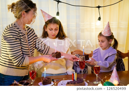 Celebrating a joyous birthday party with friends and family in a cozy setting filled with laughter and delicious treats during an evening gathering 126520499