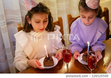 Celebrating a joyful birthday gathering with laughter, sweet treats, and sparkling beverages in a cozy indoor setting during an evening get together 126520500