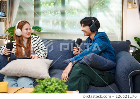 Two young people recording podcast at home with headphones and microphones 126521176
