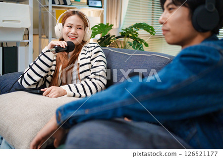 Podcast conversation between young man and woman with headphones and microphones Podcast conversation between young man and woman with headphones and microphones 126521177