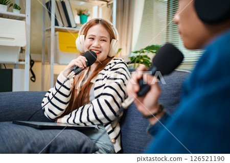 Podcast conversation between young man and woman with headphones and microphones Podcast conversation between young man and woman with headphones and microphones 126521190