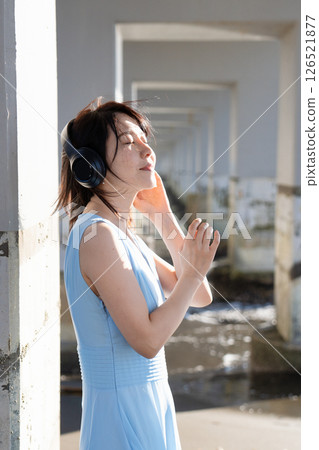 Sleeveless woman listening to music outdoors Sleeveless woman listening to music outdoors 126521877