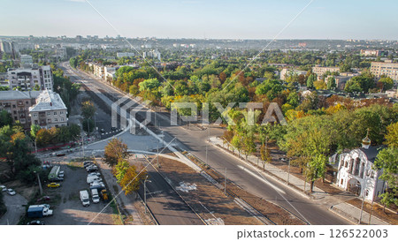 Construction site of avenue with asphalt paver, roller and truck aerial timelapse. Construction site of avenue with asphalt paver, roller and truck aerial timelapse. 126522003