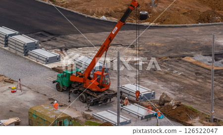 Installing concrete plates by crane at road construction site timelapse. 126522047