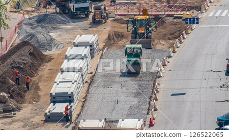 Green vibration roller compactor rolls on a stones at road construction and repairing timelapse Green vibration roller compactor rolls on a stones at road construction and repairing timelapse 126522065
